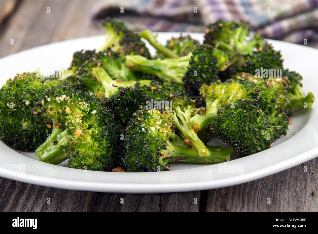 Cotto arrosto parmigiano aglio e olio di oliva broccoli lato piatto sul tavolo in legno Foto Stock