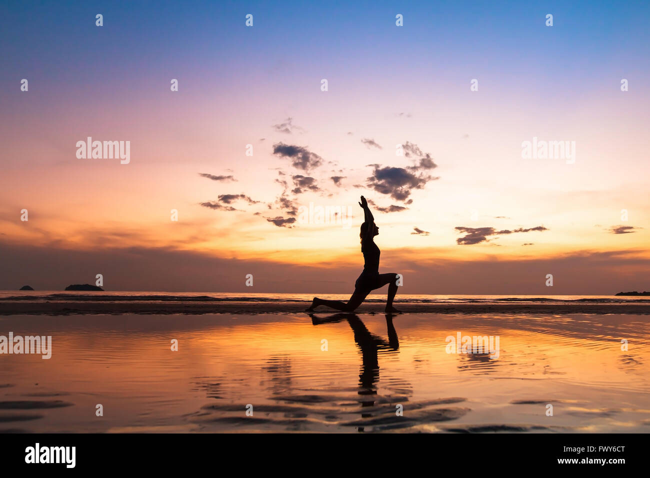 Bella esercizi yoga sulla spiaggia al tramonto, sfondo con copyspace Foto Stock