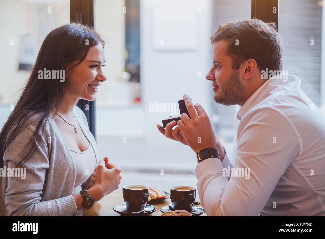 Proposta di impegno, concetto, coppia felice nel ristorante, uomo offre l'anello, sposarsi me Foto Stock