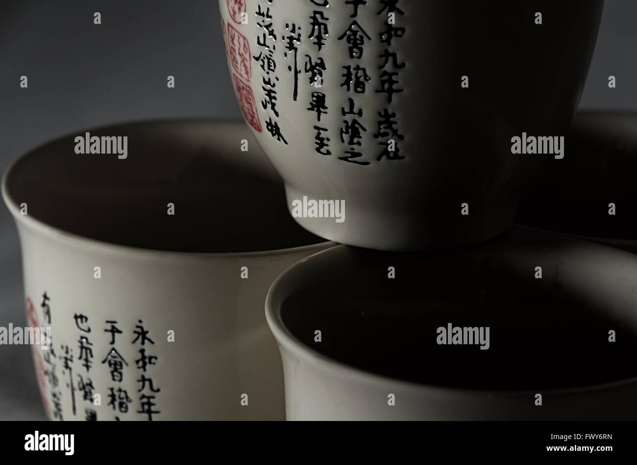 Tre tazze con simboli chenese, sfondo nero Foto Stock