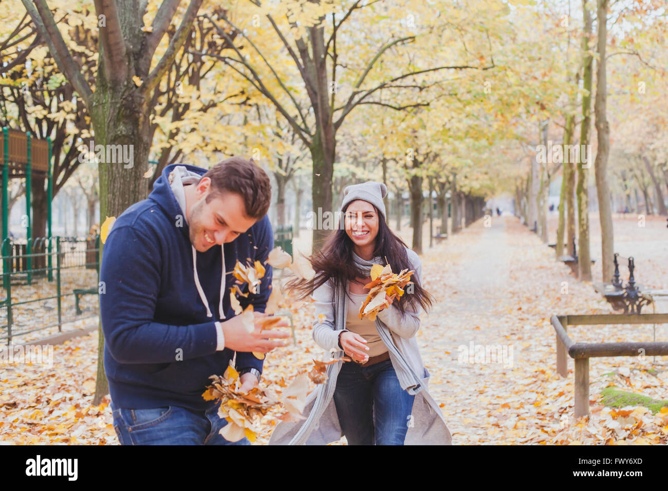 Felice coppia giovane di giocare e ridere insieme in autunno park Foto Stock