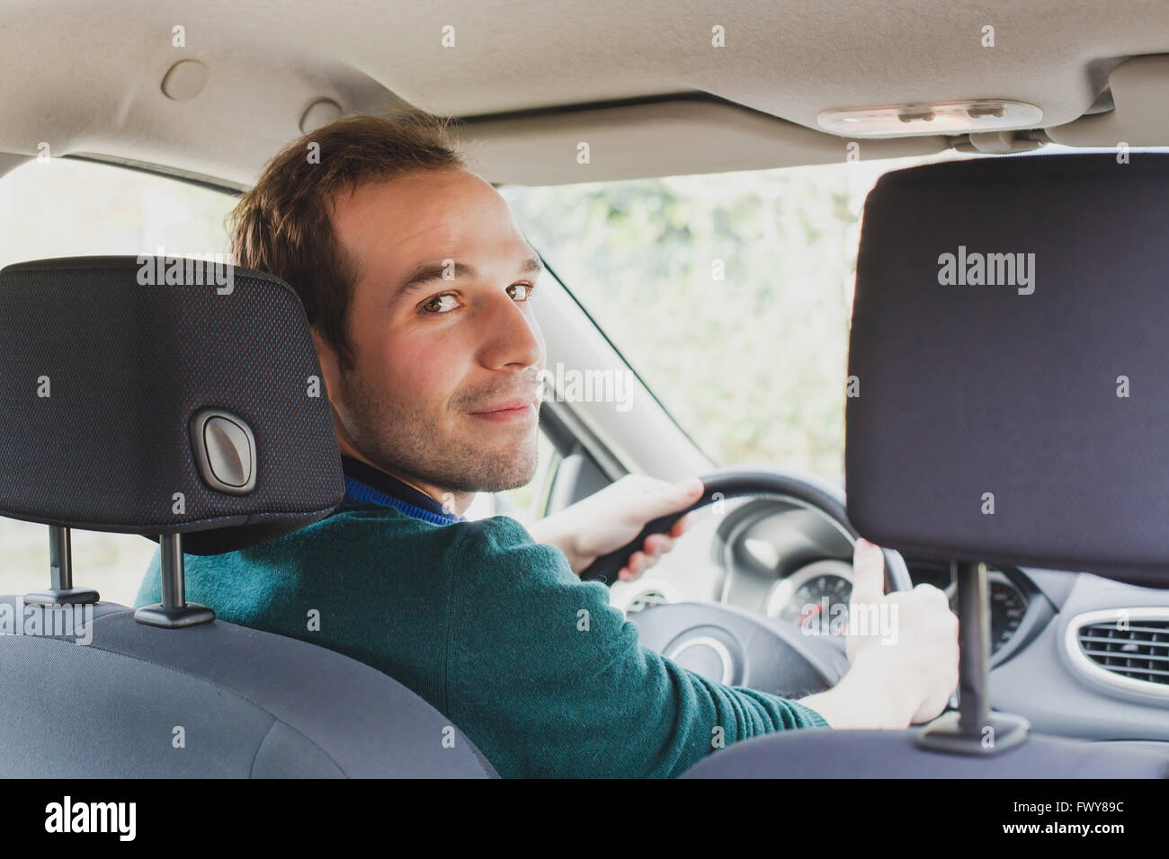 Ritratto di conducente in auto o taxi, giovane uomo caucasico Foto Stock