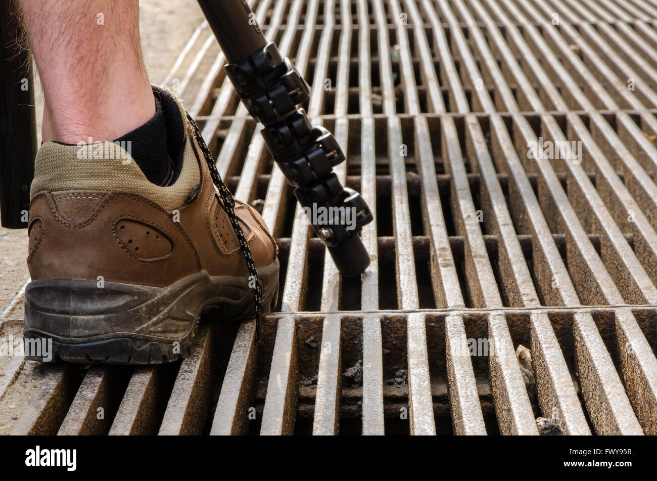 Treppiede e gamba umana nelle scarpe marrone. Foto Stock