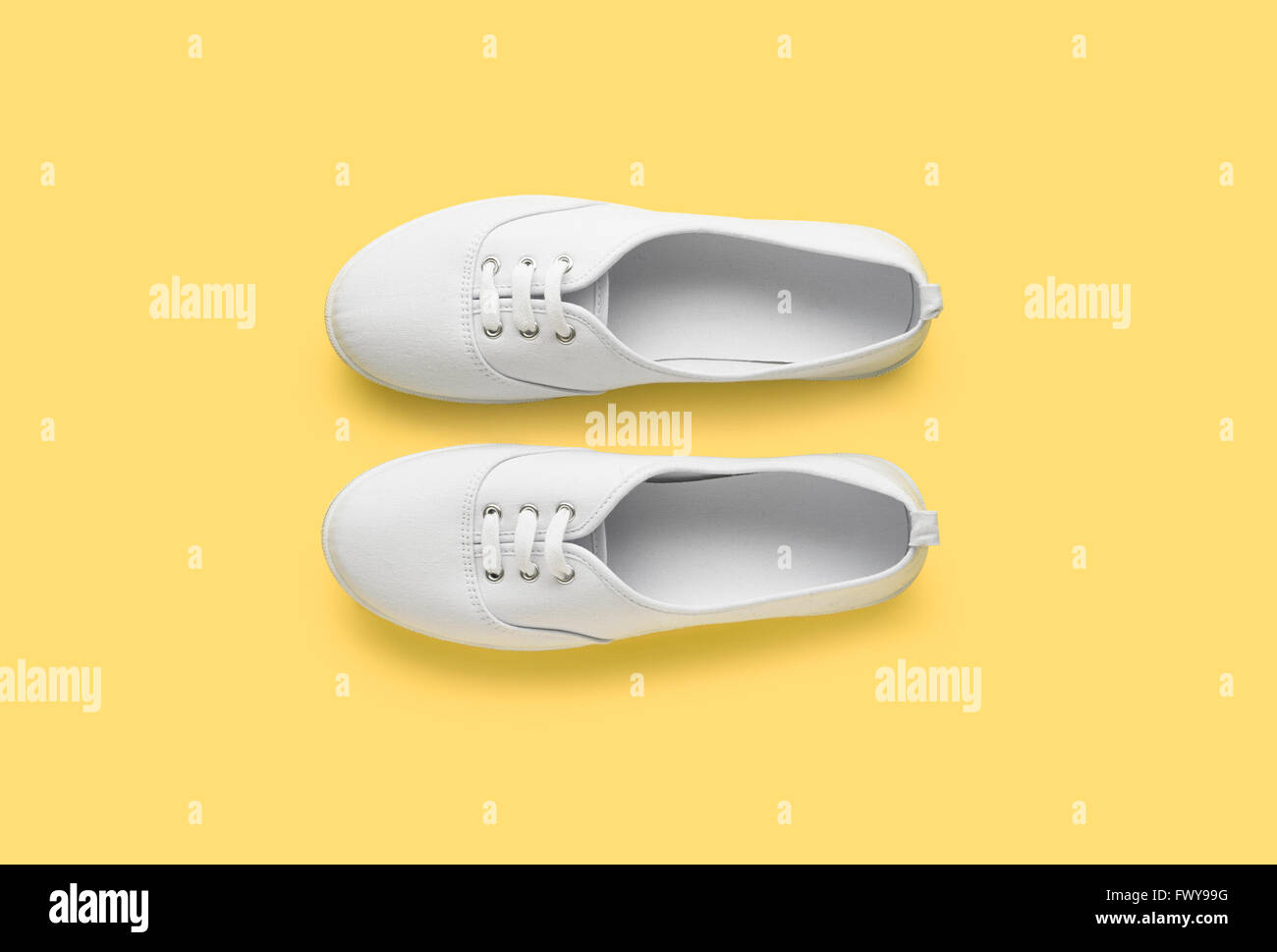 Coppia scarpe bianco sfondo giallo Foto Stock