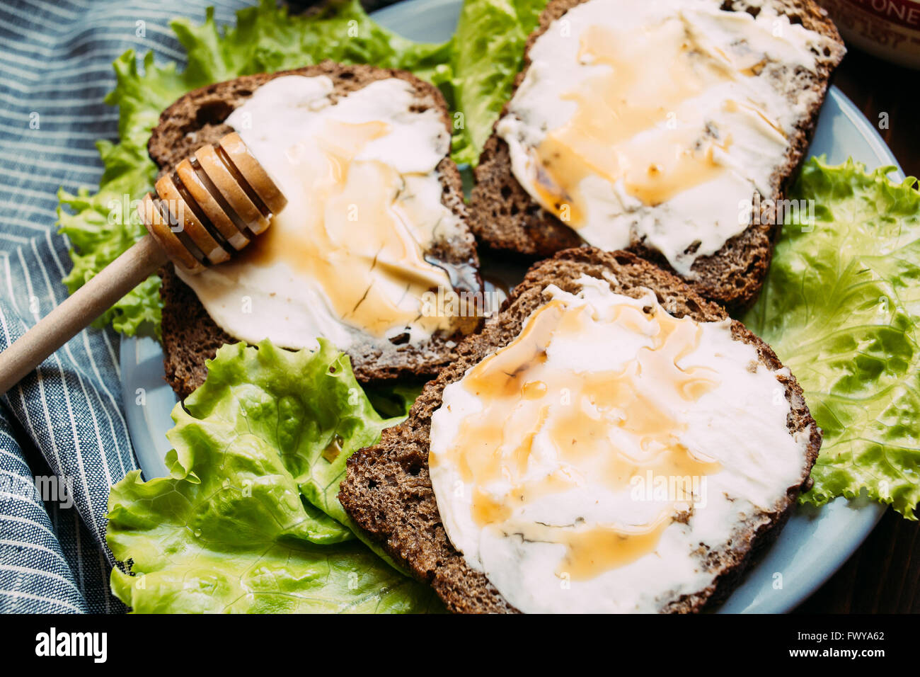 Sandwich di pane di segale, formaggio a pasta morbida, insalata fresca Foto Stock