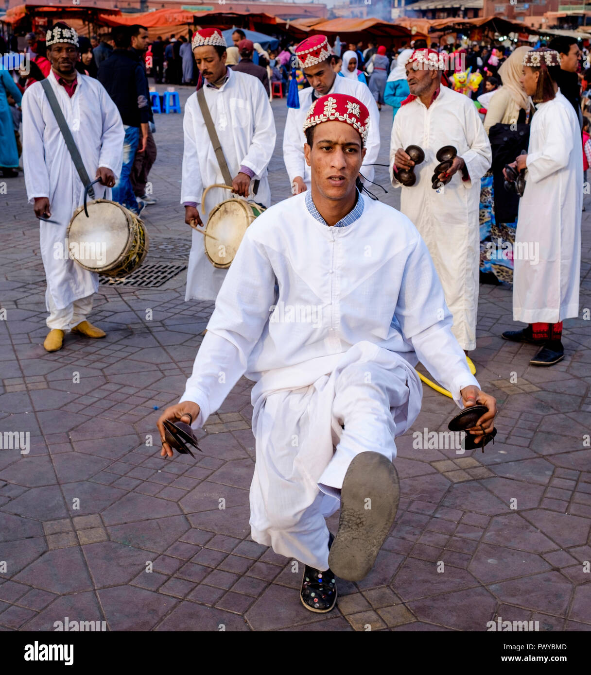 Gli uomini suonando la batteria ed eseguire una danza tradizionale in Piazza Jemaa el Fna a Marrakech, Marocco, Africa del Nord Foto Stock