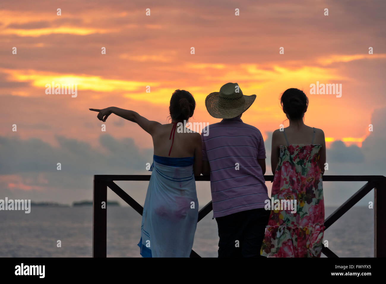 I turisti a guardare il tramonto sulla spiaggia, Maldive Foto Stock