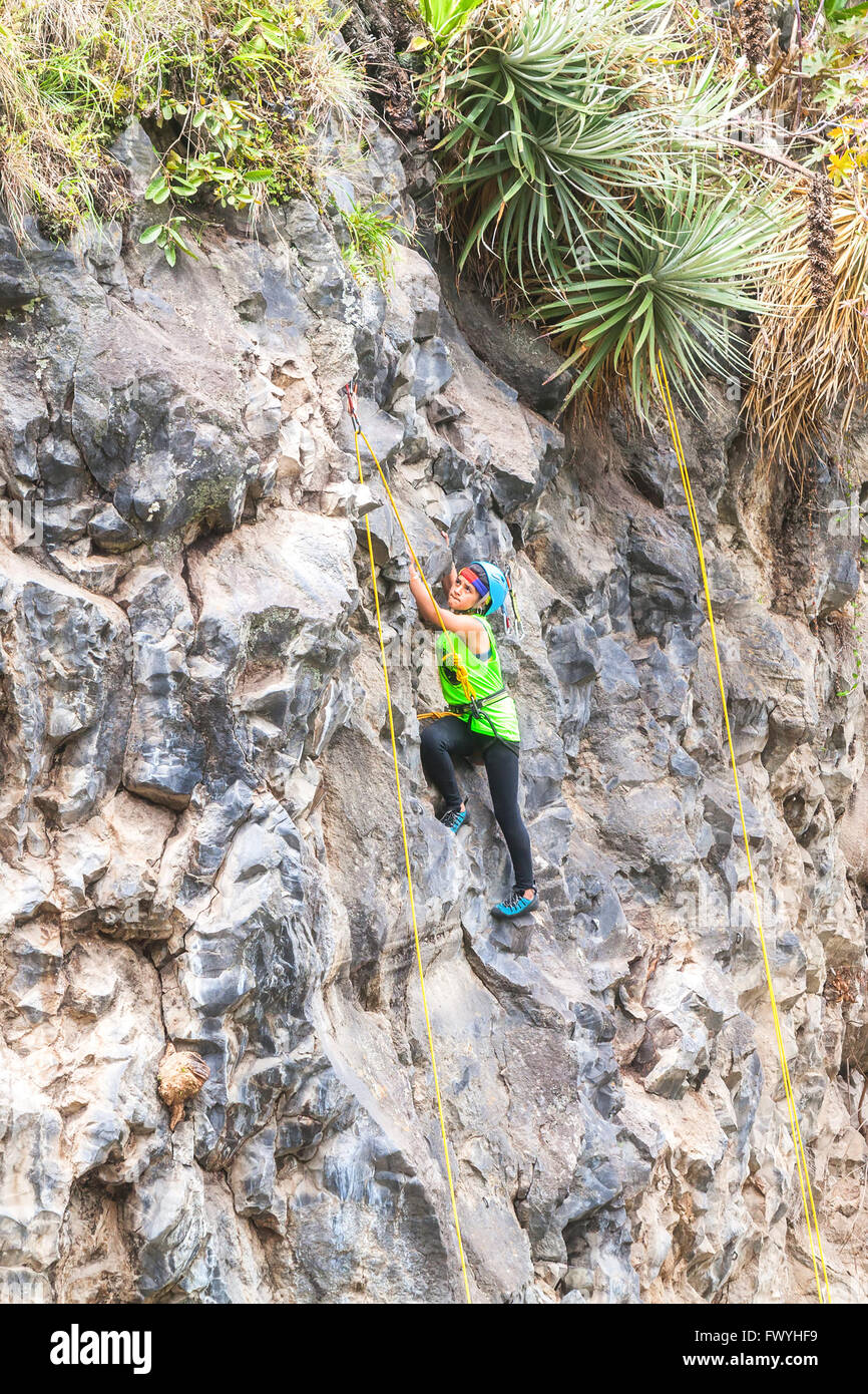 Banos, Ecuador - 30 Novembre 2014: la sfida di basalto del Tungurahua, Teen ragazza latina salendo una verticale Parete di roccia, Sud America Foto Stock