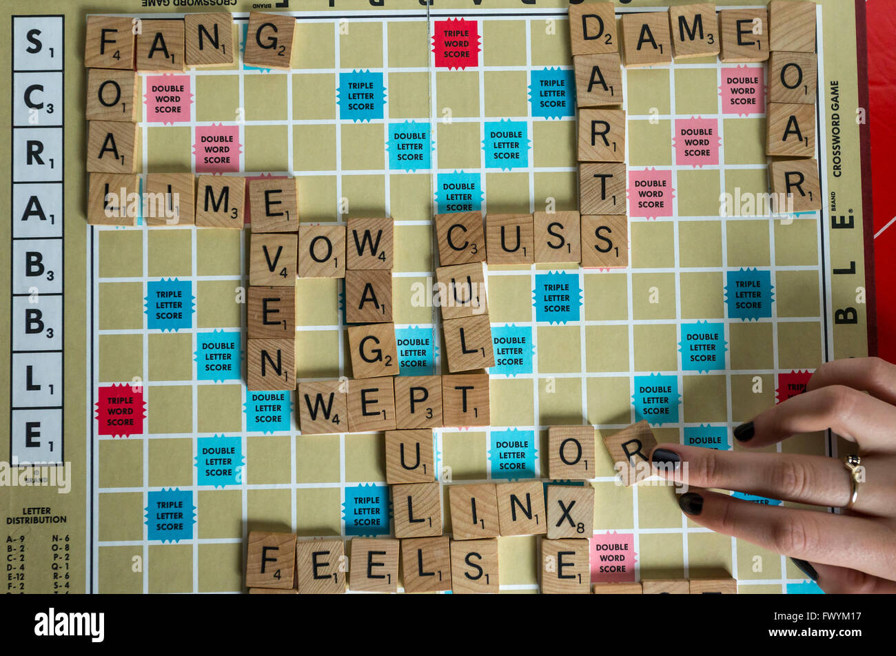 Primo piano della mano collocando lettera sul gioco SCRABBLE board-Victoria, British Columbia, Canada. Foto Stock