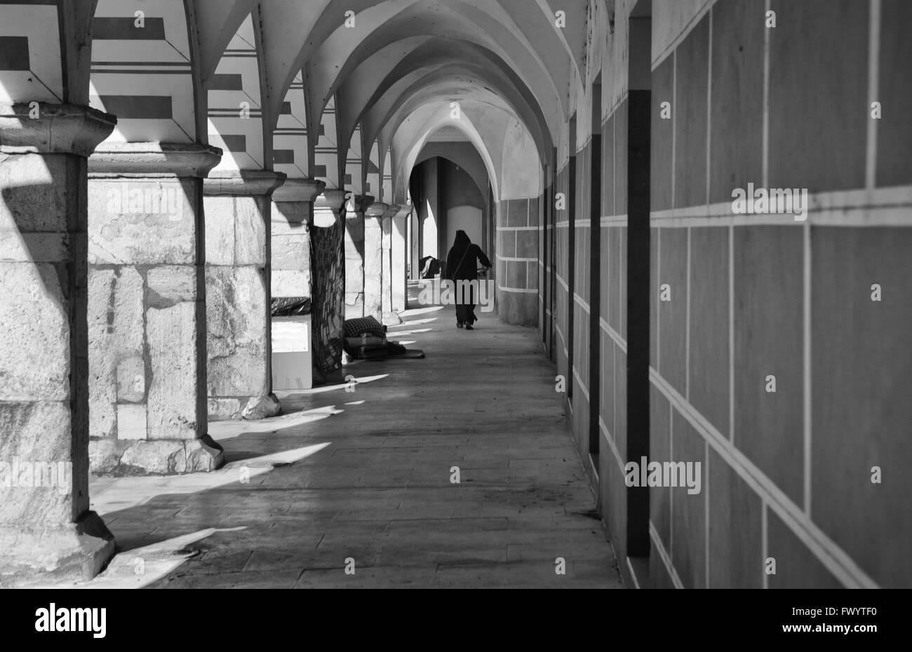 Abito uomo uo come arabo merchant camminare sotto gli archi della piazza Alta portico di Badajoz, Spagna durante la cultura Almossasa Fest Foto Stock