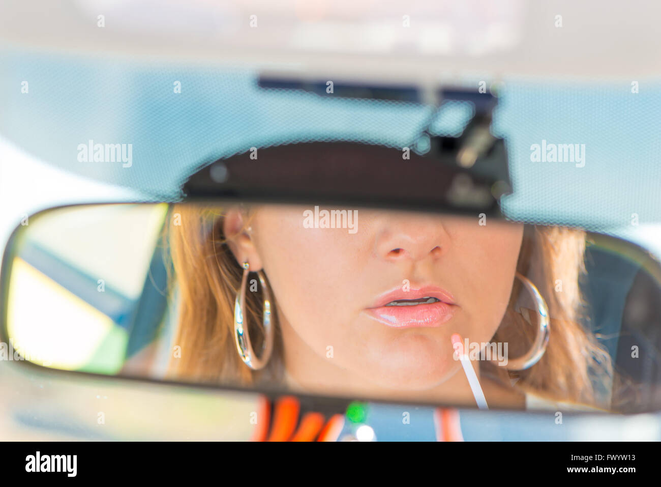 Auto specchietto retrovisore close-up girl si applica il rossetto Foto Stock