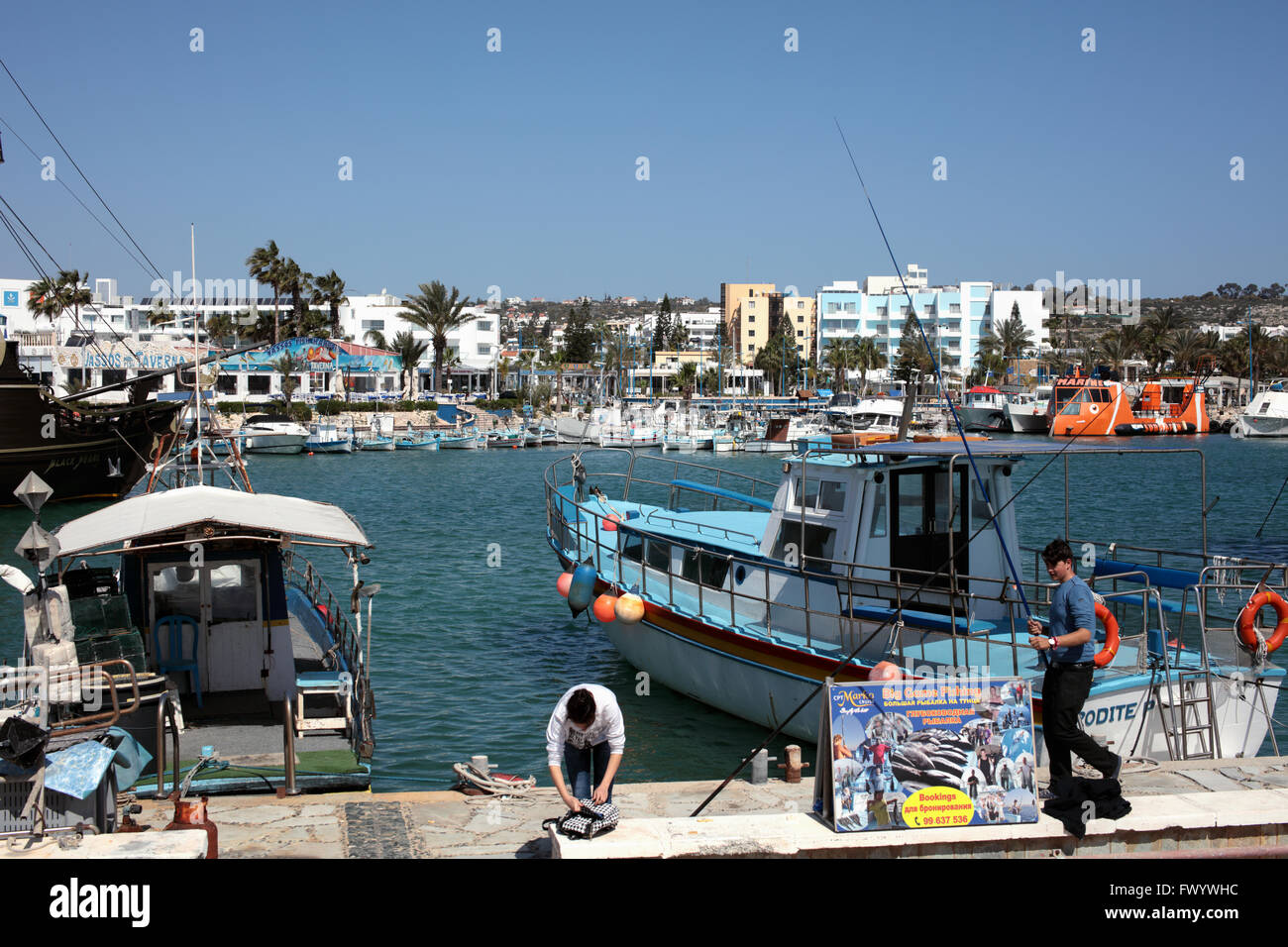 Giovane pescatore a barche da pesca nel porto di Ayia Napa, Cipro Foto Stock