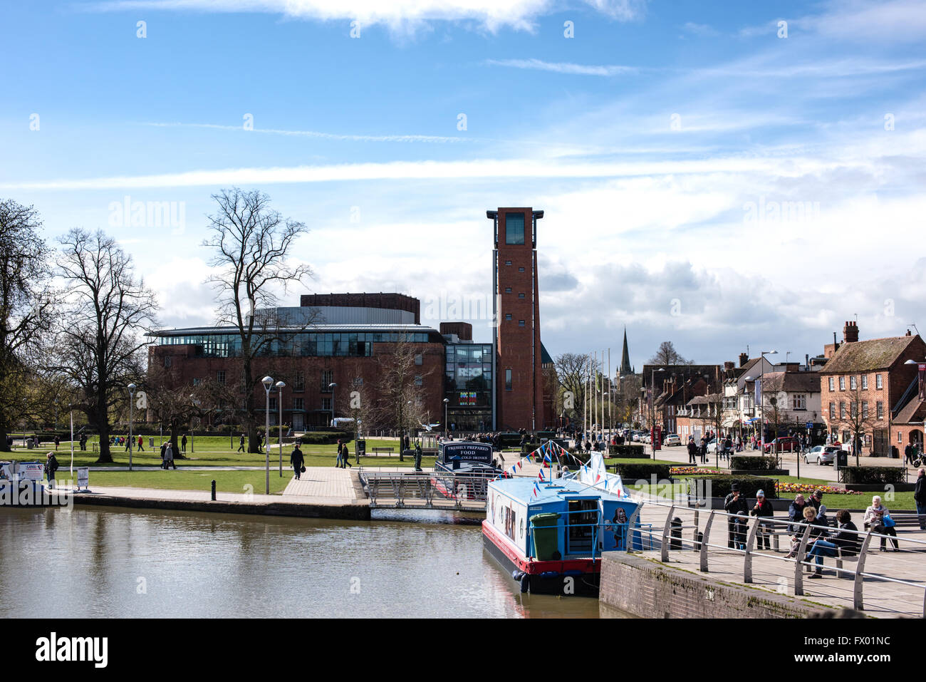 Vista l'RSC Swan Theatre, Stratford-upon-Avon con il fiume, bacino del canale e narrowboats ormeggiata su una soleggiata mattina di primavera e la gente a piedi Foto Stock