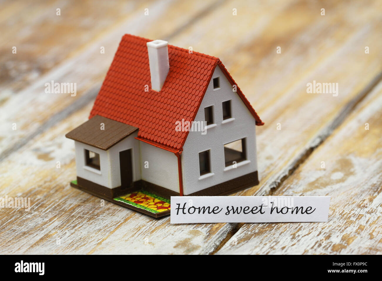 Home sweet home card con il modello in miniatura di una casa Foto Stock