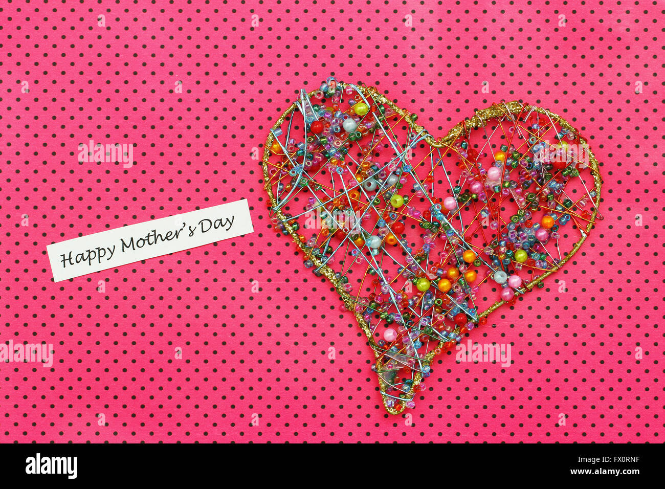 Felice Festa della mamma card con cuore di perline colorate rosa su sfondo dotty Foto Stock