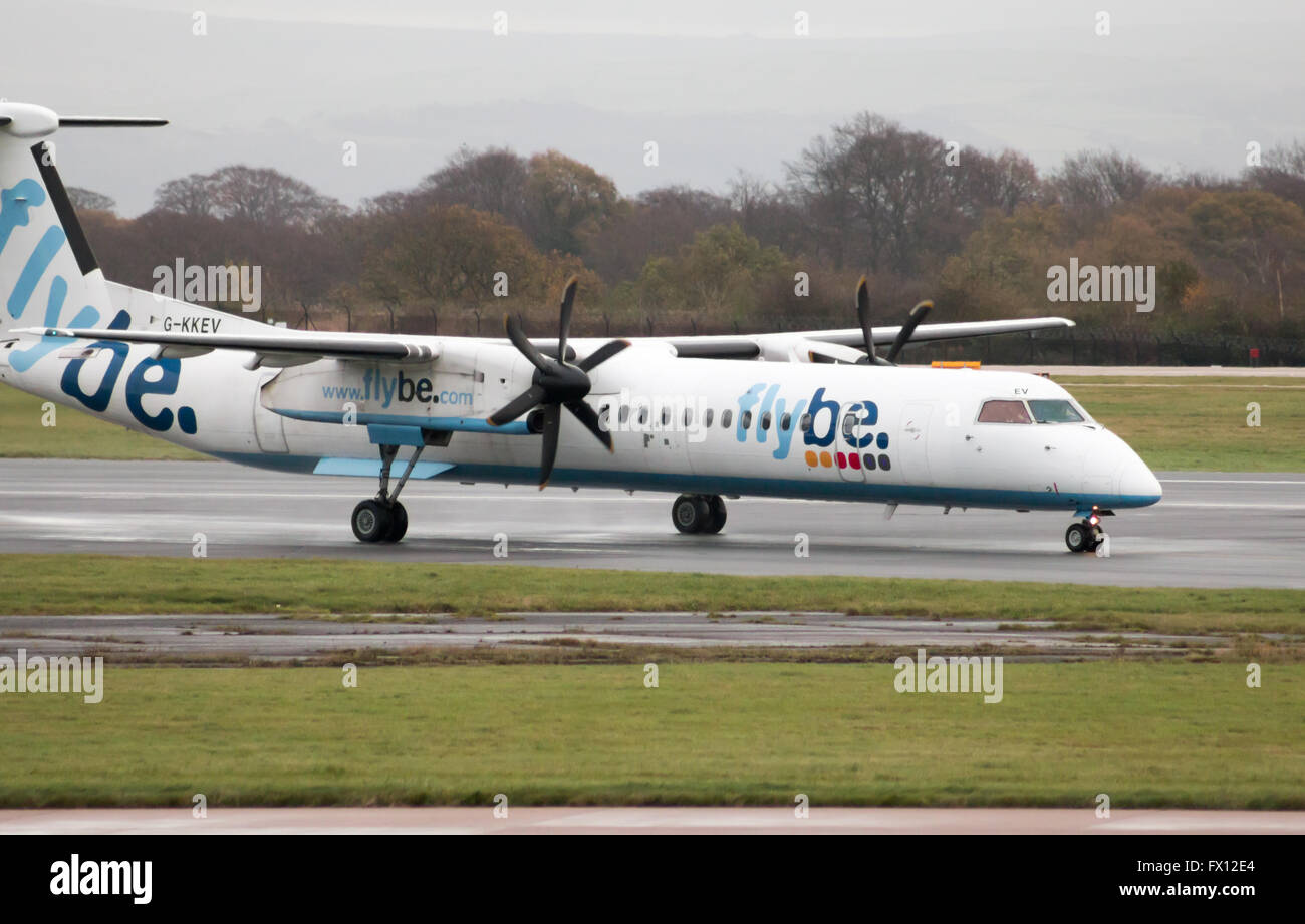 Flybe Bombardier Dash 8 Q400 medio raggio a doppio motore aereo passeggeri (G-KKEV) rullaggio sull'Aeroporto Internazionale di Manchester. Foto Stock