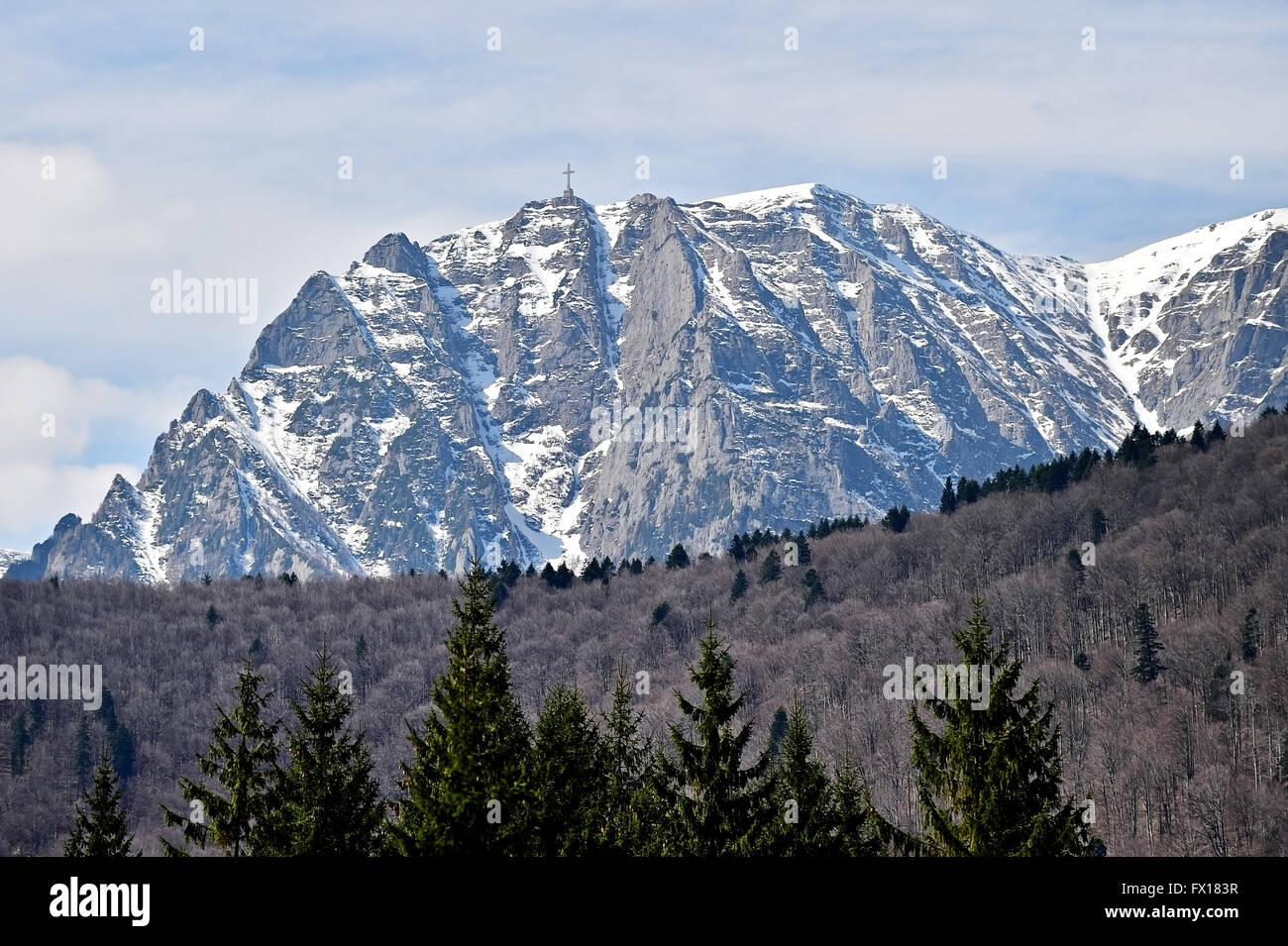 Montagne di Bucegi in inverno con gli eroi Monumento a croce sulla sommità del picco di Caraiman. La Croce è dedicato per il rumeno di eroi Foto Stock