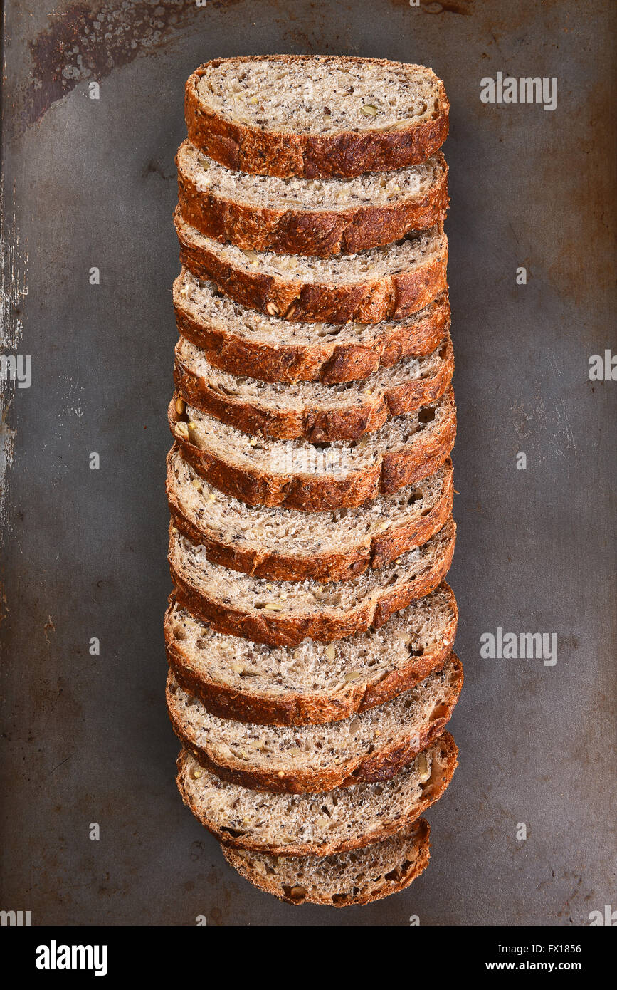 Vista dall'alto di una forma di pane a fette di multi-pane di grano su una placca da forno. Foto Stock