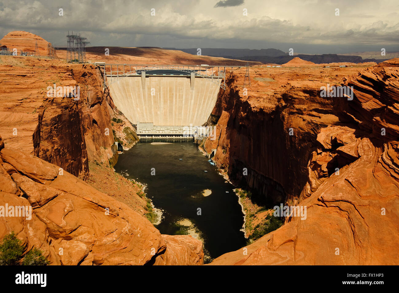 Glenn Canyon Dam e il ponte sul fiume Colorado. Una diga in calcestruzzo che provoca il lago Powell visibile appena oltre la diga. Foto Stock