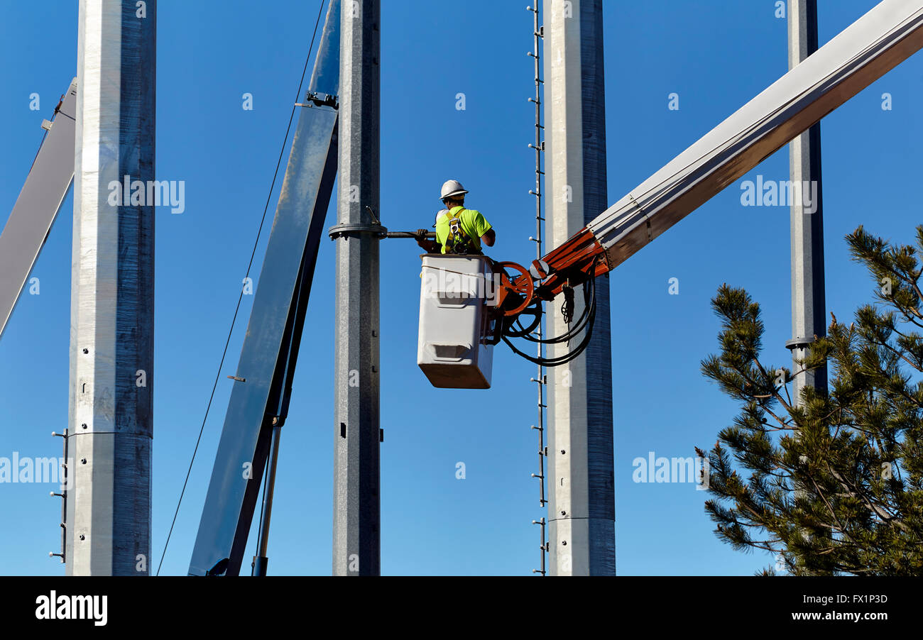 Lavoratore di utilità in un braccio gru cestello utility manutenzione poli Foto Stock