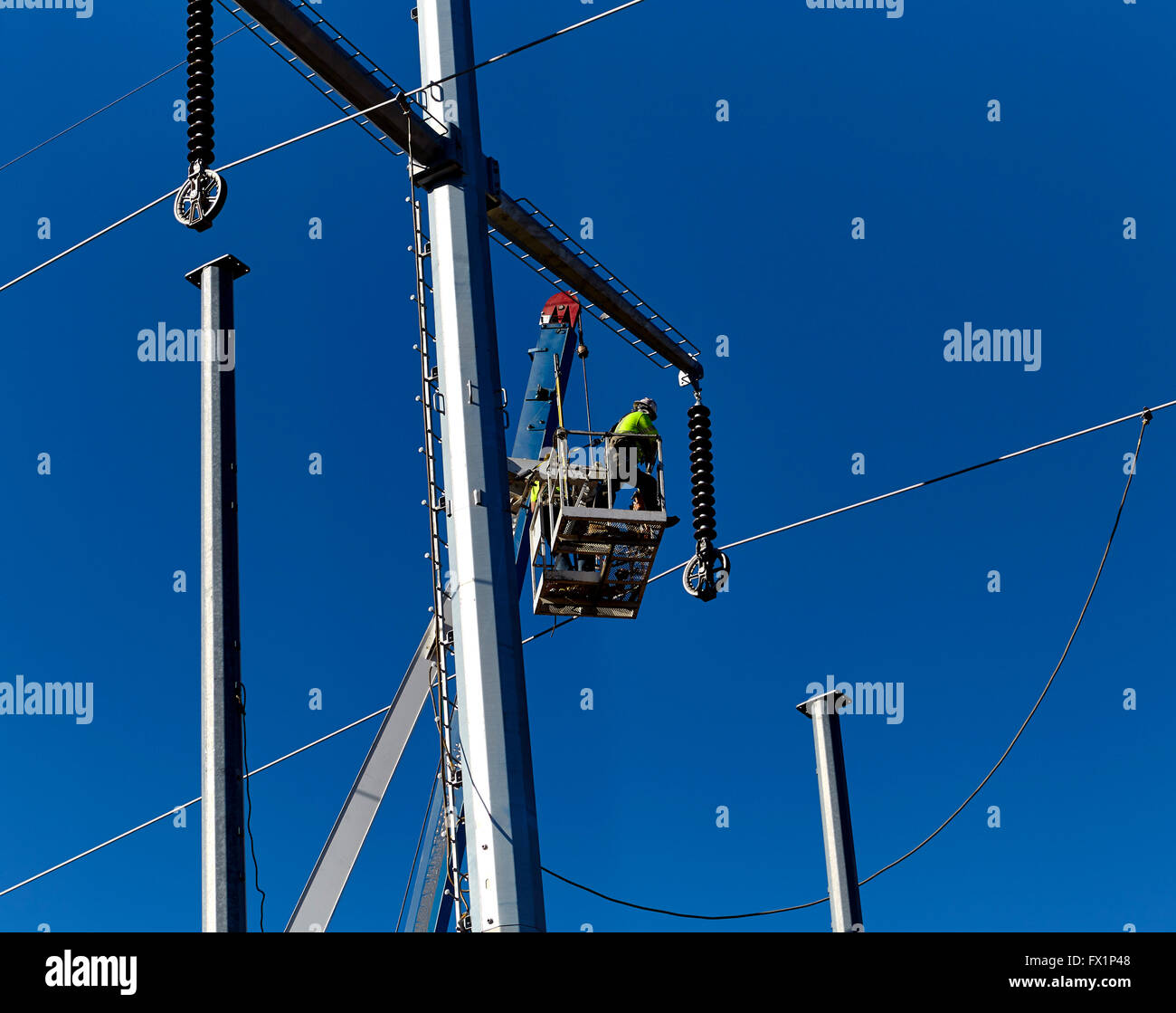 Lavoratore di utilità in un braccio gru cestello utility manutenzione poli Foto Stock