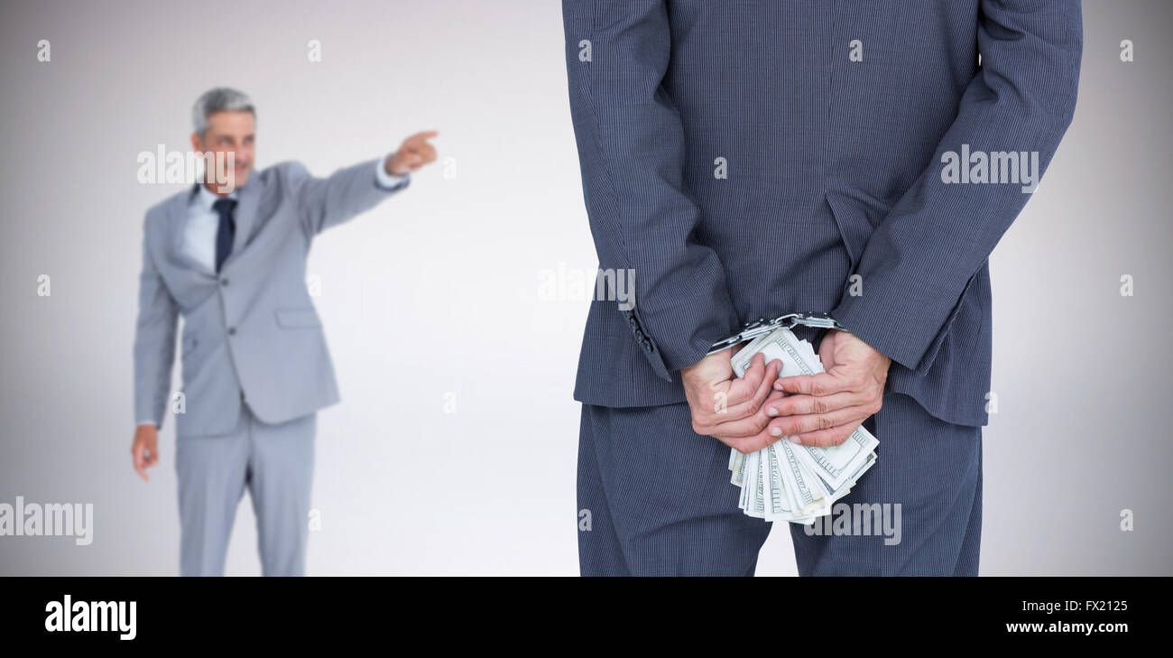 Immagine composita della vista posteriore di imprenditore con manette e delle banconote in euro Foto Stock