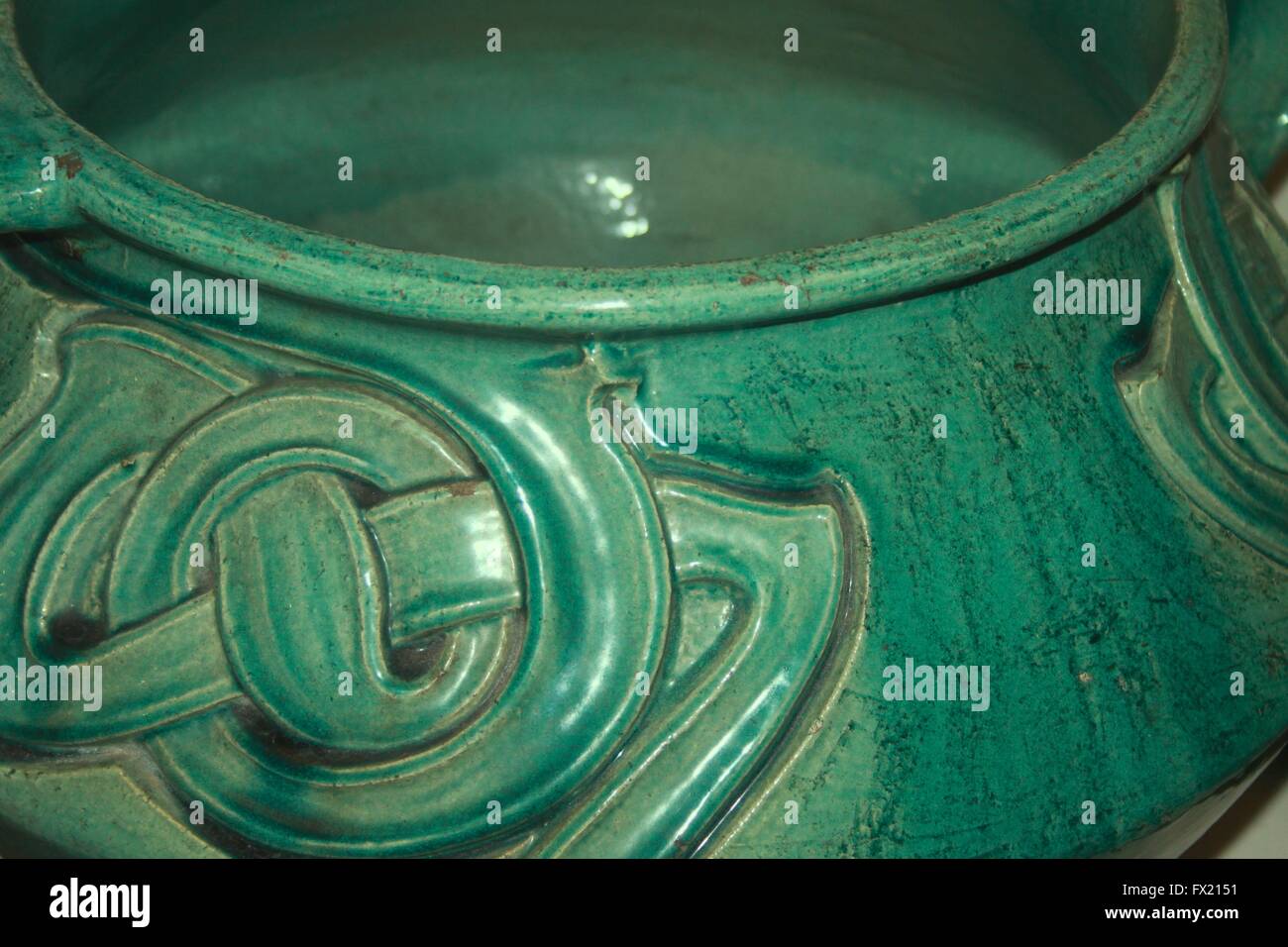 Close up di un verde pot vetrata con un arti e mestieri o arte nouveaux nodo celtico design Foto Stock