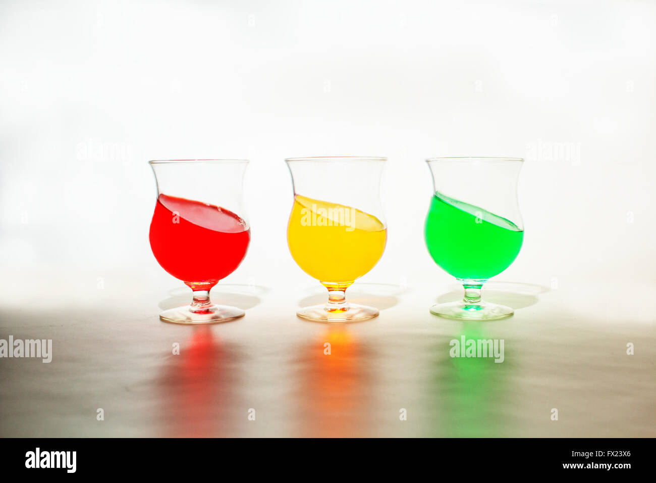 Rosso, giallo e verde di gelatina in bicchieri. La gelatina è inclinata per dare un aspetto divertente per l'immagine. Foto Stock