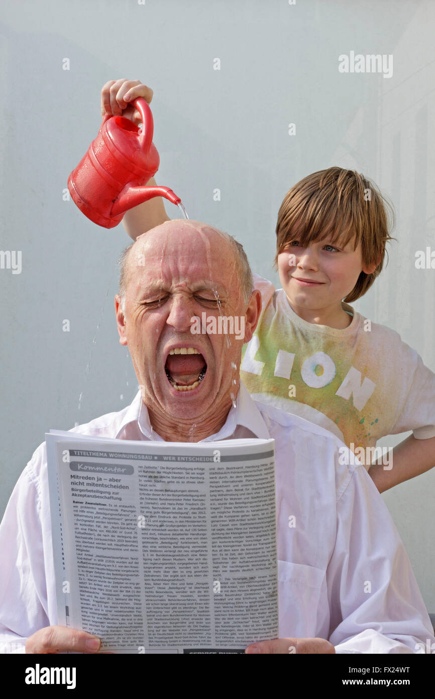 Naughty boy versando acqua su un uomo di testa Foto Stock