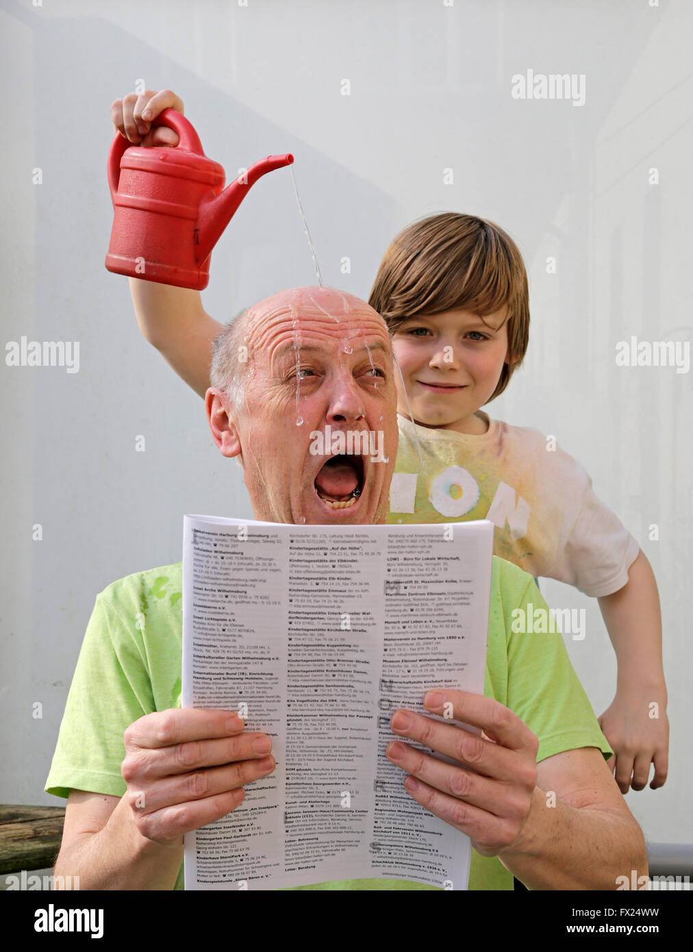 Naughty boy versando acqua su un uomo di testa Foto Stock