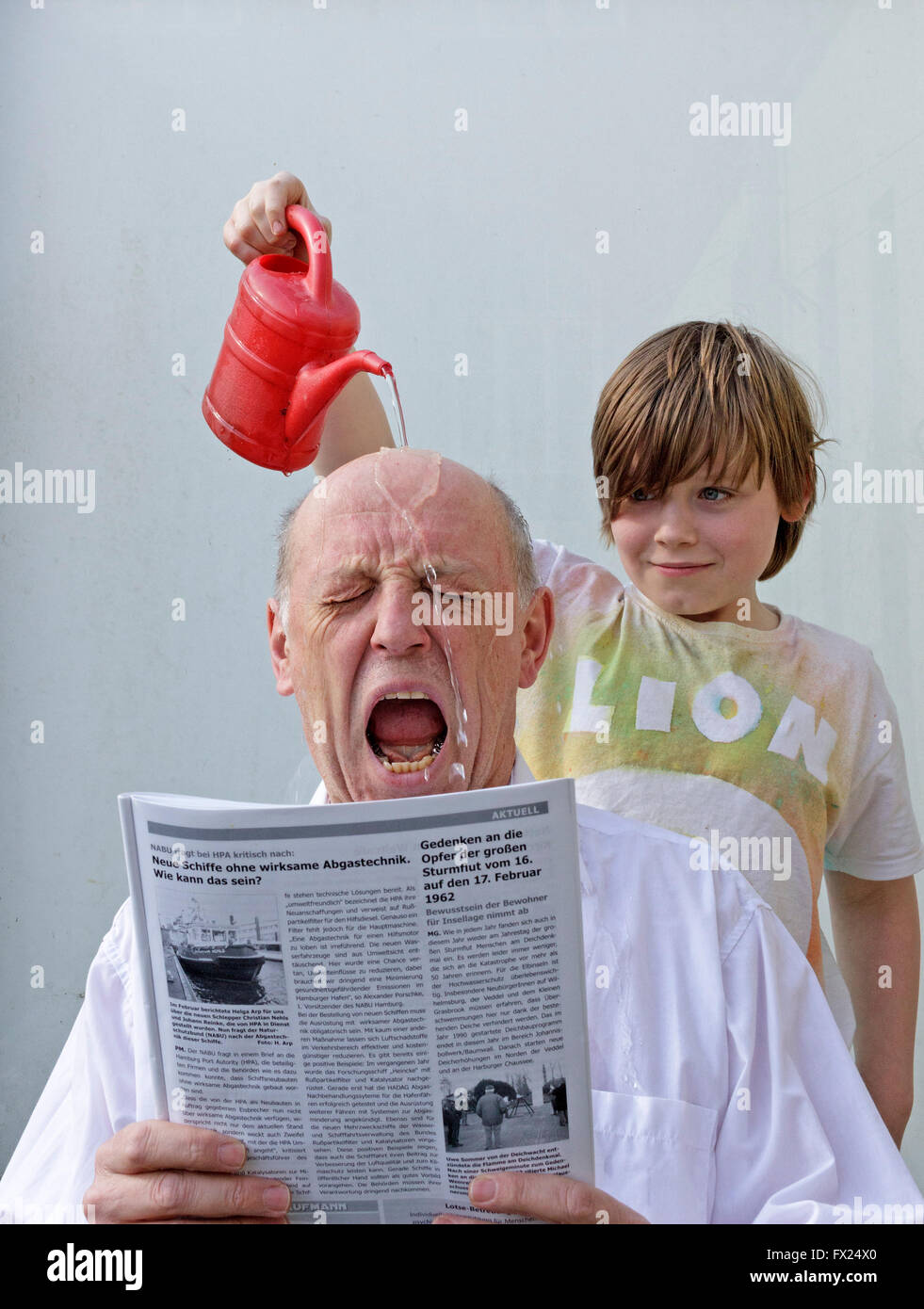 Naughty boy versando acqua su un uomo di testa Foto Stock