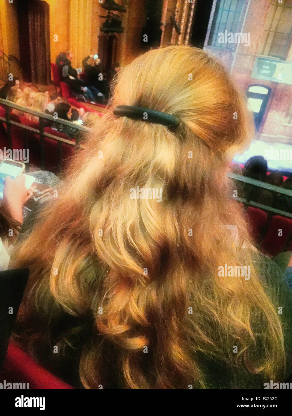 Testa piena di ondulati capelli biondi su una donna ad uno spettacolo di Broadway, New York, Stati Uniti d'America Foto Stock