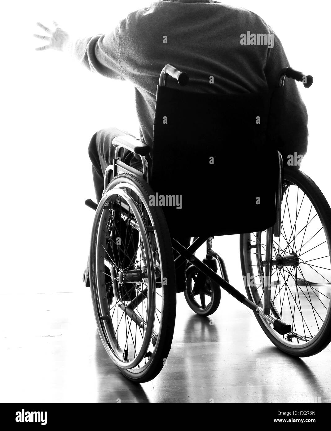 Anziani disabili seduto in una sedia a rotelle nella sua stanza Foto Stock