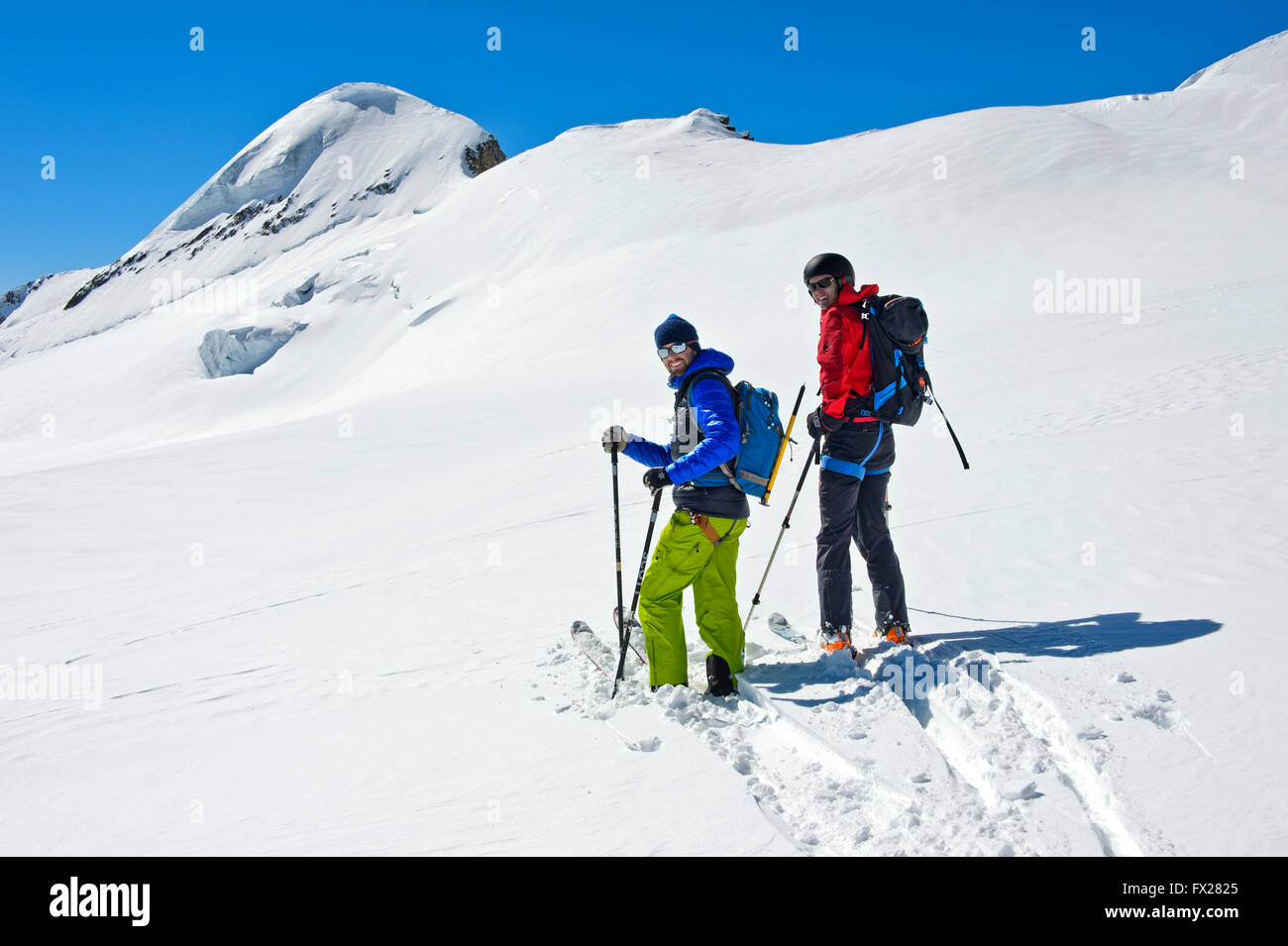 Due gli sciatori su un tour di sci sulla canna fumaria Aebeni firn fiel al di sotto del picco Mittagshorn, Loetschental, Vallese, Svizzera Foto Stock