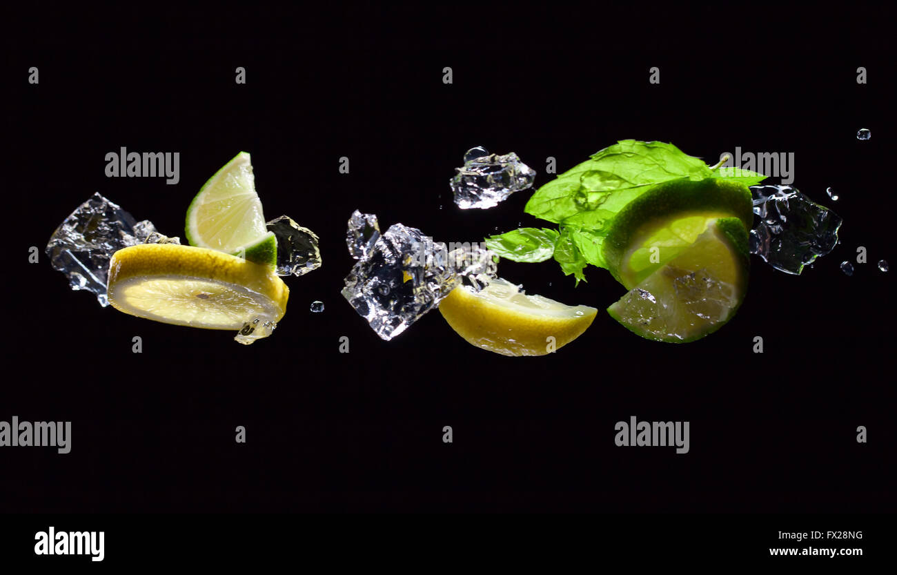 Calce e pezzi di limone con foglie di menta piperita Foto Stock