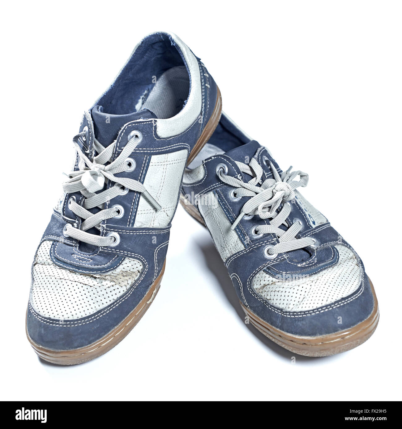 Vecchi e consunti sneakers isolato su bianco Foto Stock