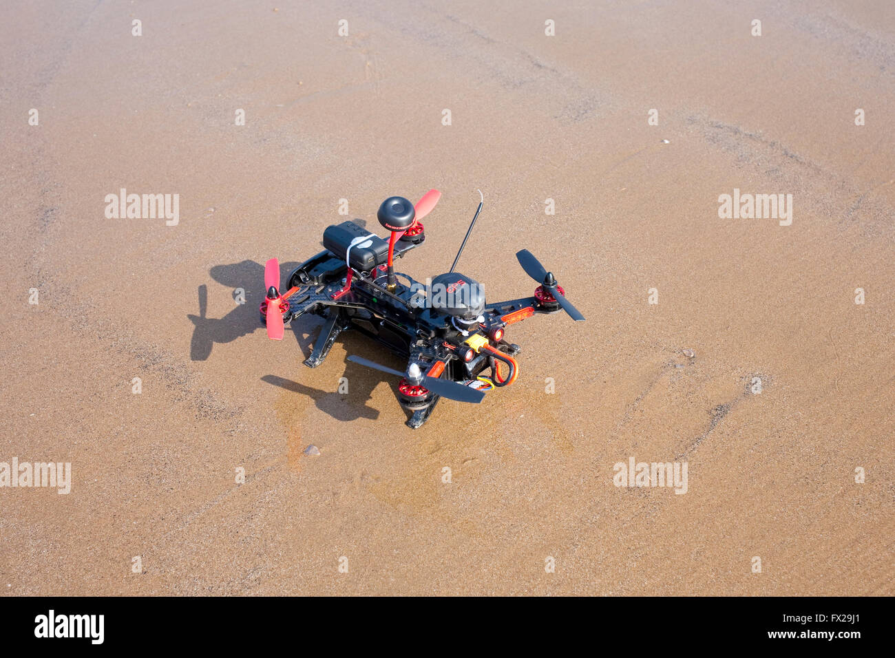 Radio Controlled drone essendo reso pronto a volare su una spiaggia deserta Foto Stock