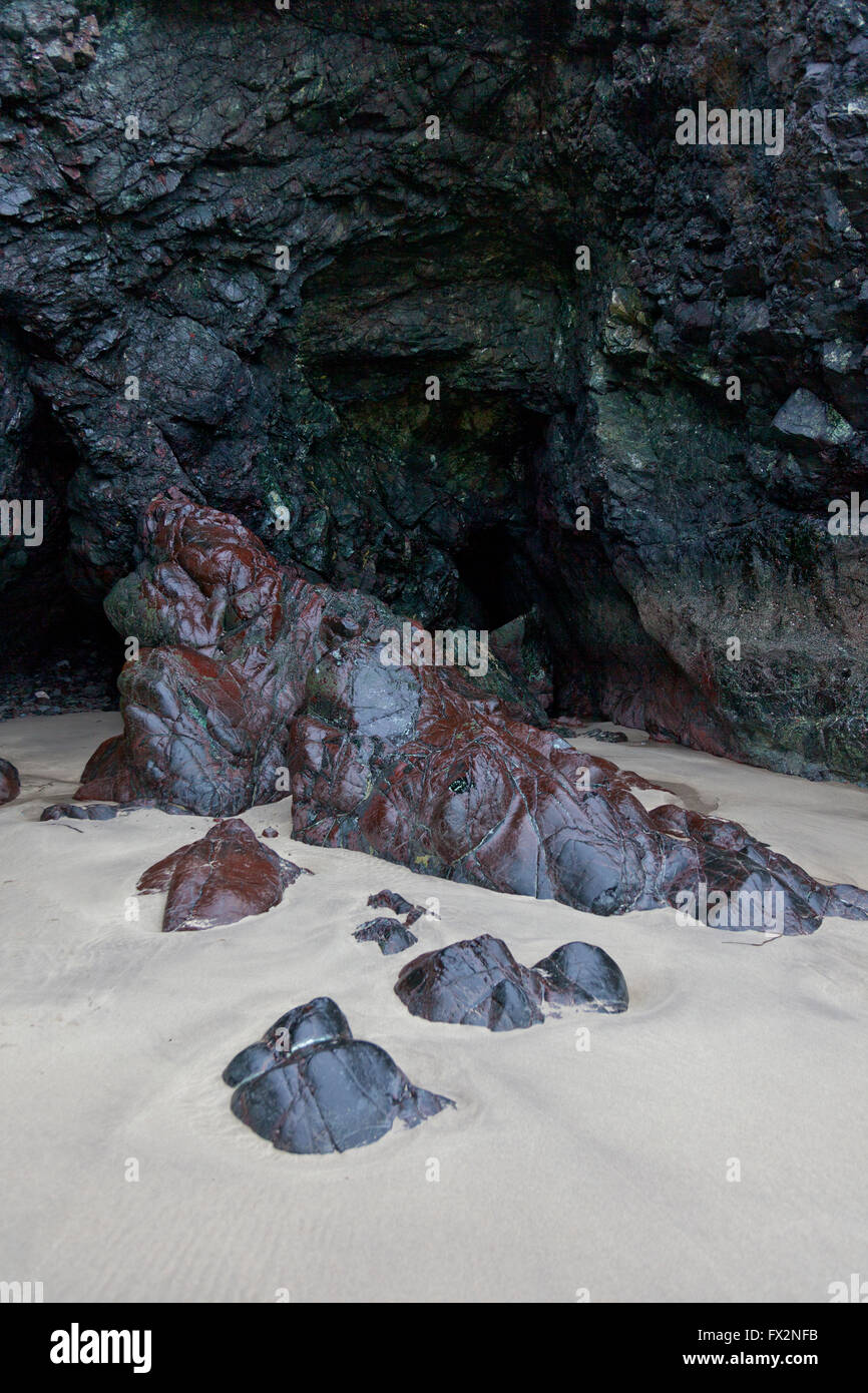 Rari affioramenti di roccia a serpentina sulla spiaggia di Kynance Cove sulla penisola di Lizard, Cornwall, Regno Unito Foto Stock