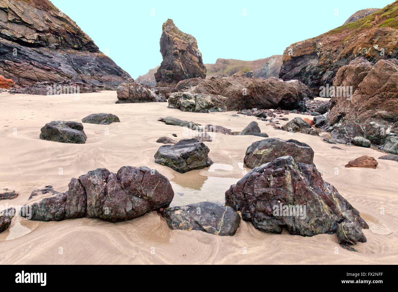 Rari affioramenti di roccia a serpentina sulla spiaggia di Kynance Cove sulla penisola di Lizard, Cornwall, Regno Unito Foto Stock
