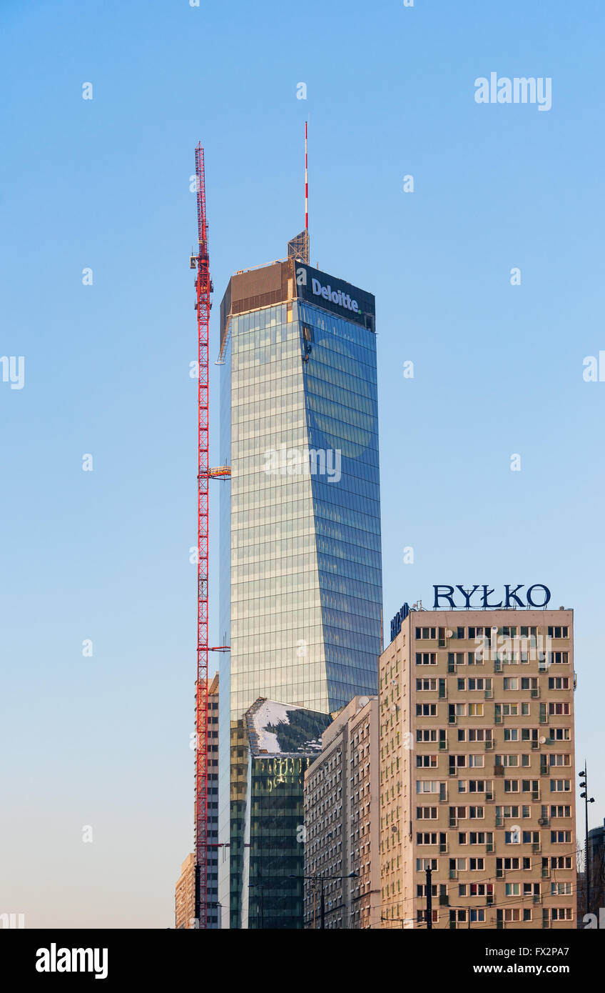 Ufficio moderno blocco di Varsavia in fase di costruzione con una gru e lavoratori di arrampicata. Un grattacielo in stile postmodernist Foto Stock