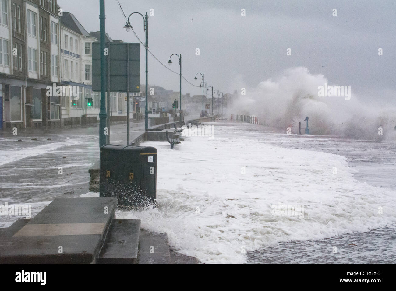 Penzance, Cornwall, Regno Unito. Il 10 aprile 2016. Regno Unito Meteo. Onde enormi con venti di 65mph ed eccezionalmente alte maree pastella Penzance lungomare alla fine delle vacanze di Pasqua. Credito: Simon Maycock/Alamy Live News Foto Stock