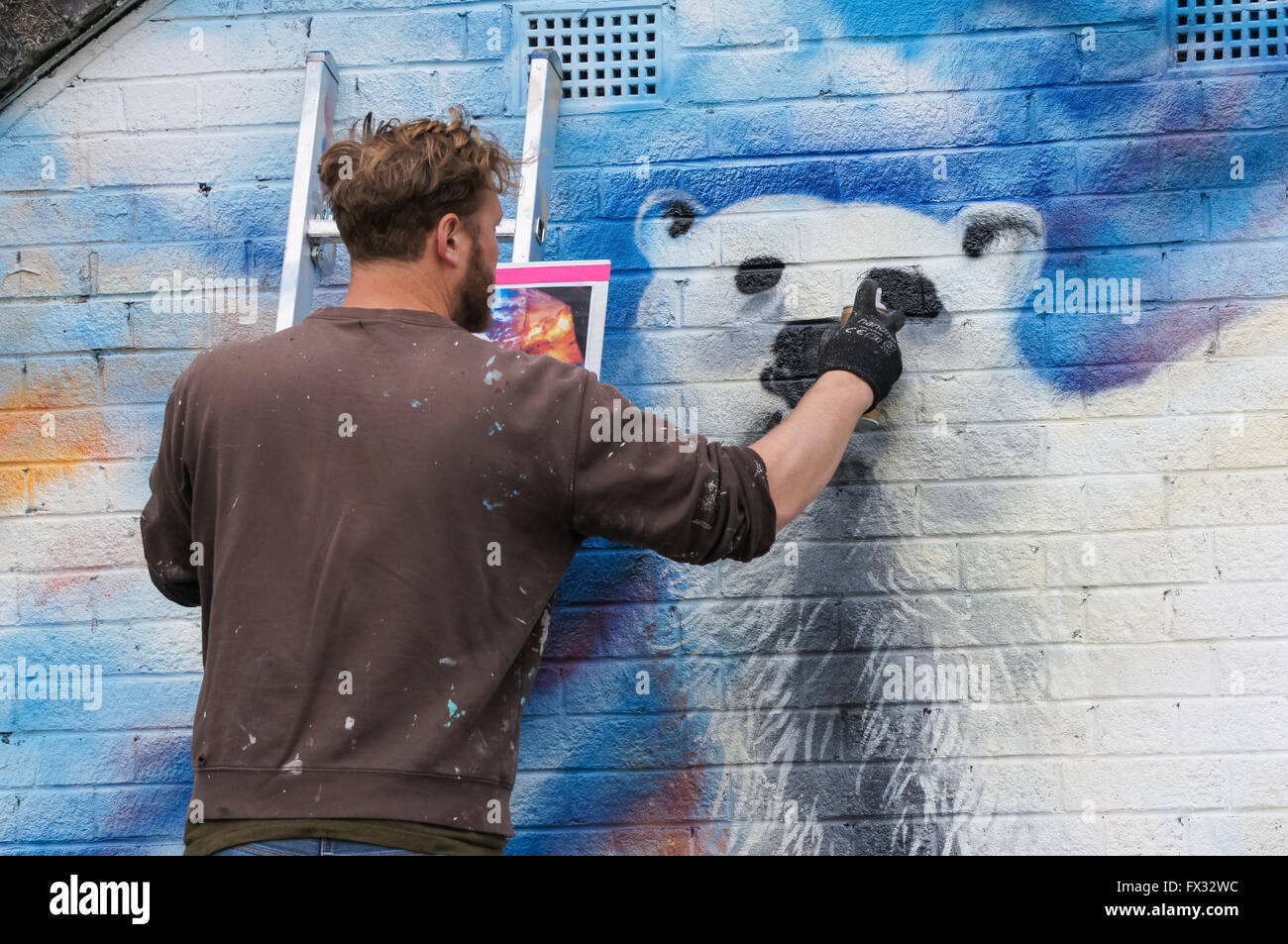 Un artista di graffiti di verniciatura a spruzzo di un coloratissimo pezzo di lavoro a Londra England Regno Unito Regno Unito Foto Stock