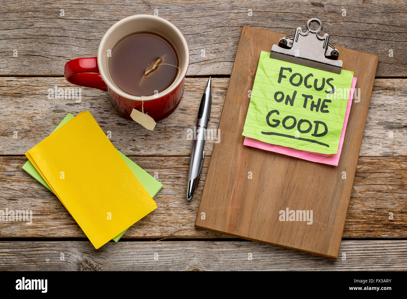 Focus sui buoni consigli o promemoria - nota adesiva su una clipboard con una tazza di tè Foto Stock