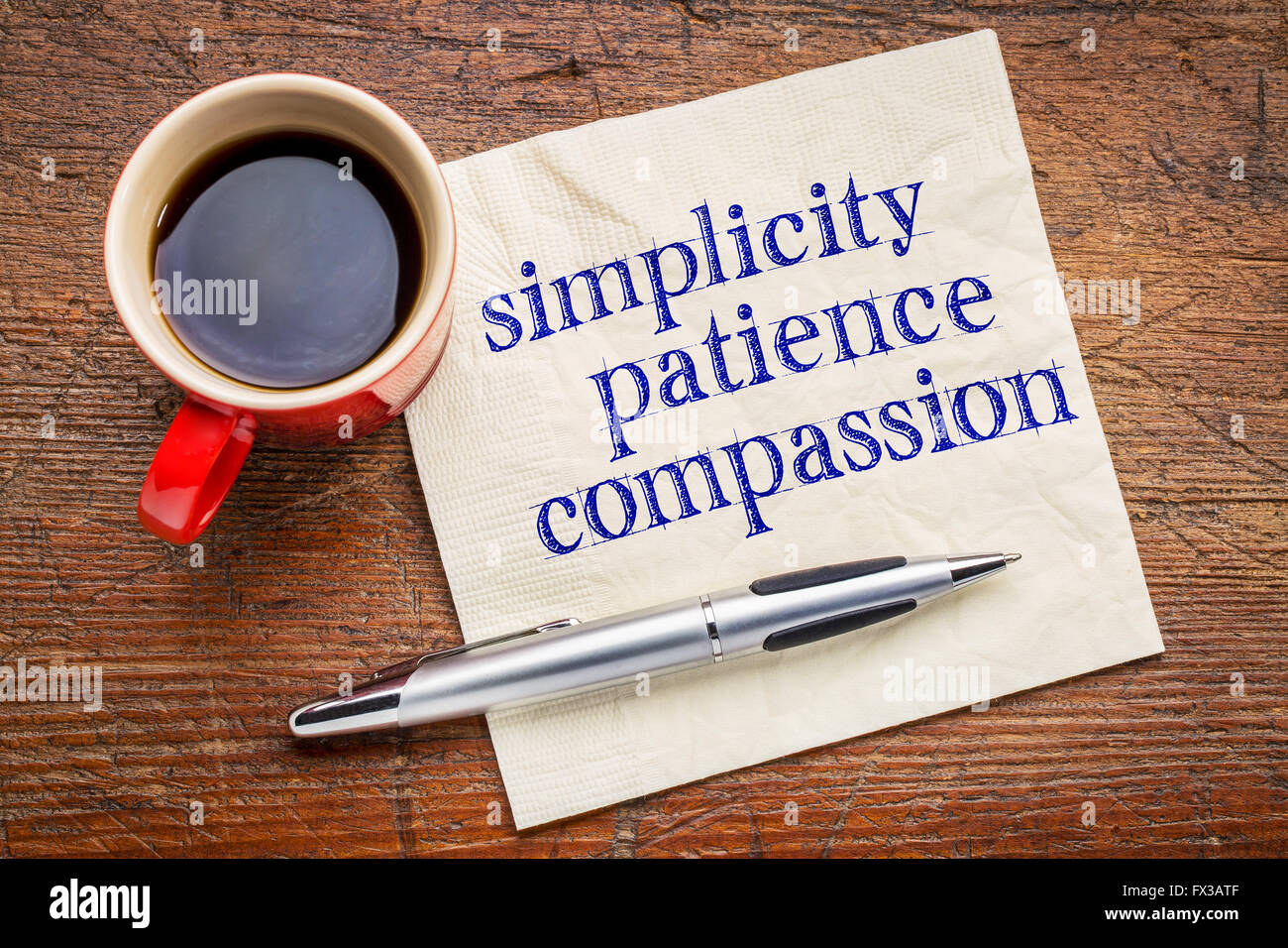 Semplicità, la pazienza e la compassione - tre parole di insegnamento di Buddha - scrittura su un tovagliolo con tazza di caffè contro grigio sl Foto Stock