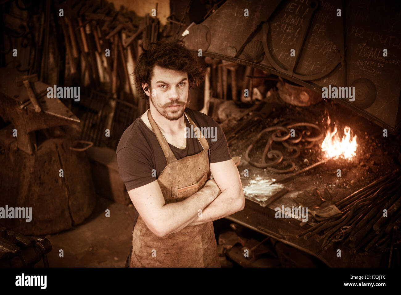 Ironworker forgiatura del ferro caldo in officina Foto Stock