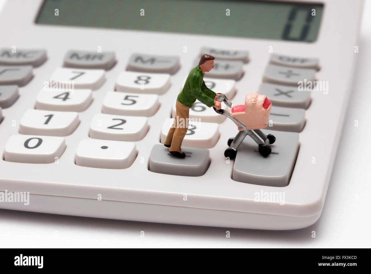 Un unico maschio statuetta in miniatura genitore spingendo una carrozzina su tasti della calcolatrice Foto Stock