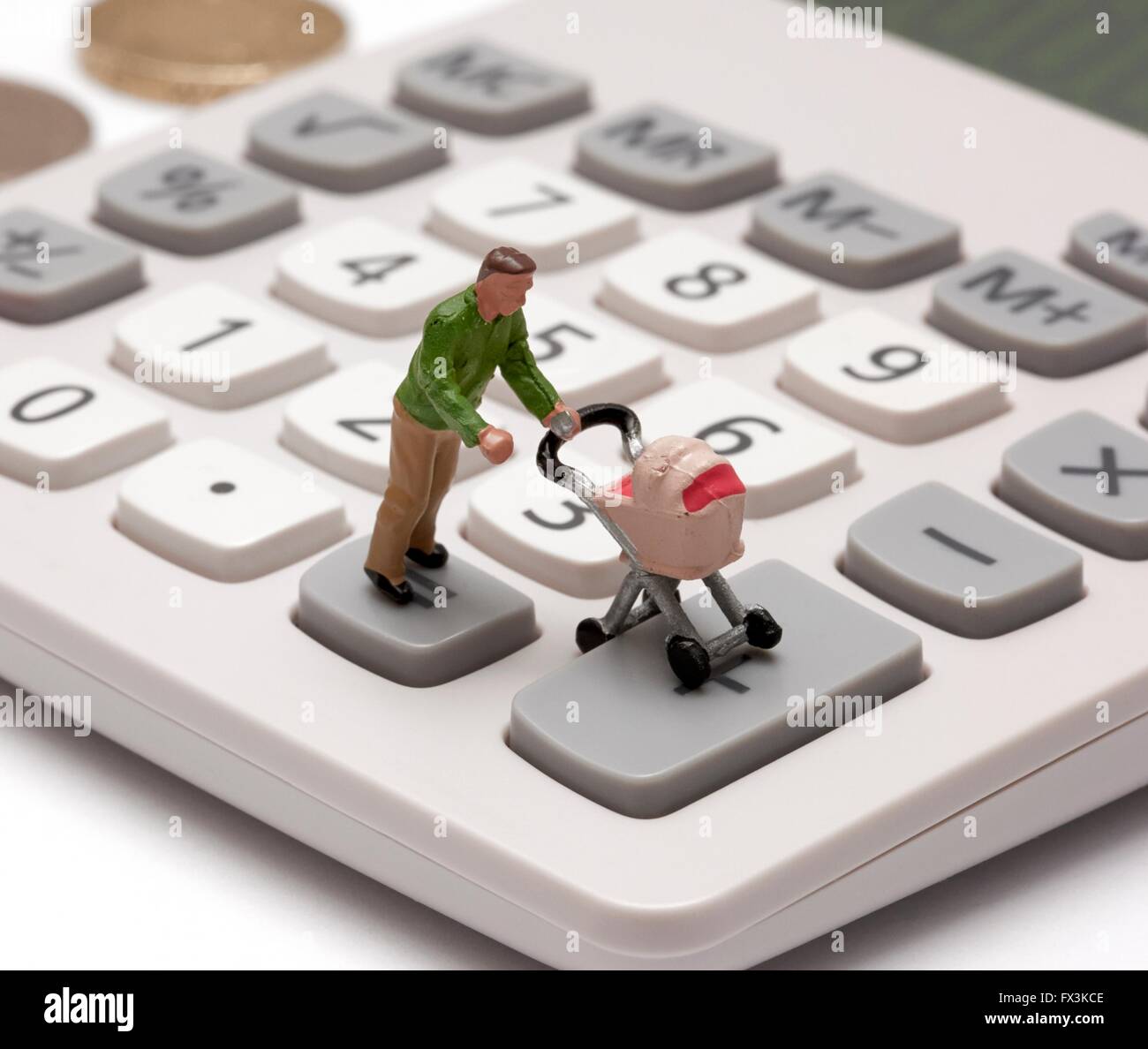 Un unico maschio statuetta in miniatura genitore spingendo una carrozzina su tasti della calcolatrice Foto Stock