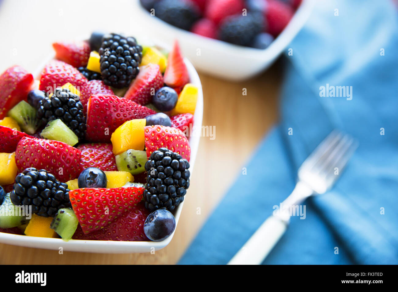 Una sana frutta fresca insalata di fragole, more, mango, mirtilli e kiwi. Foto Stock