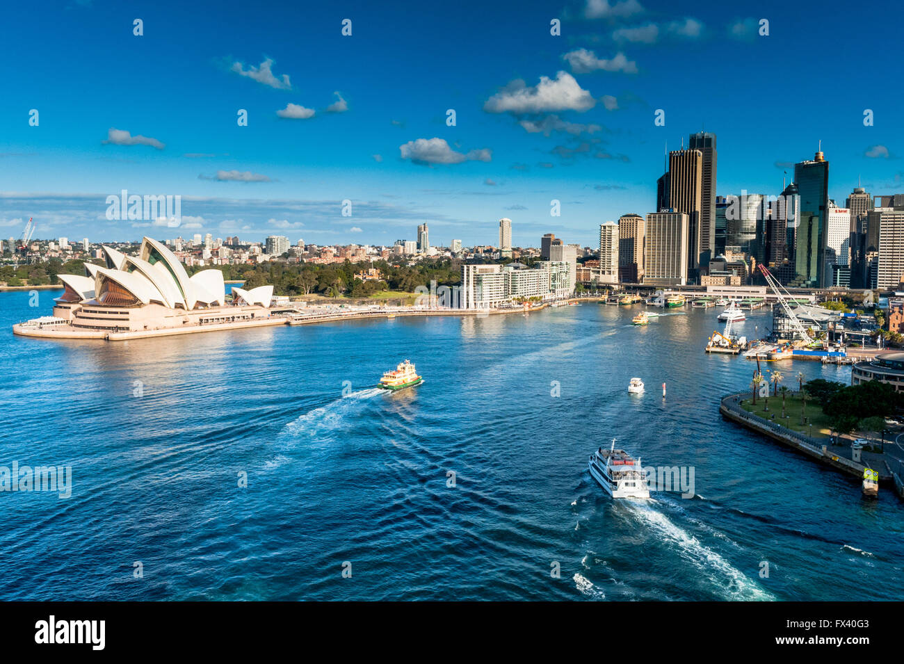 La vista dal Ponte del Porto di Sydney, Australia guardando verso il basso la Sydney Opera House e il porto con il traghetto e taxi. Foto Stock