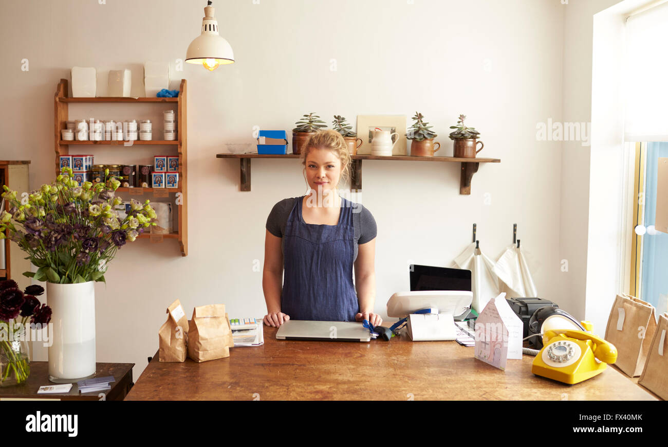 Femmina proprietario di Delicatessen in piedi al momento del checkout Foto Stock